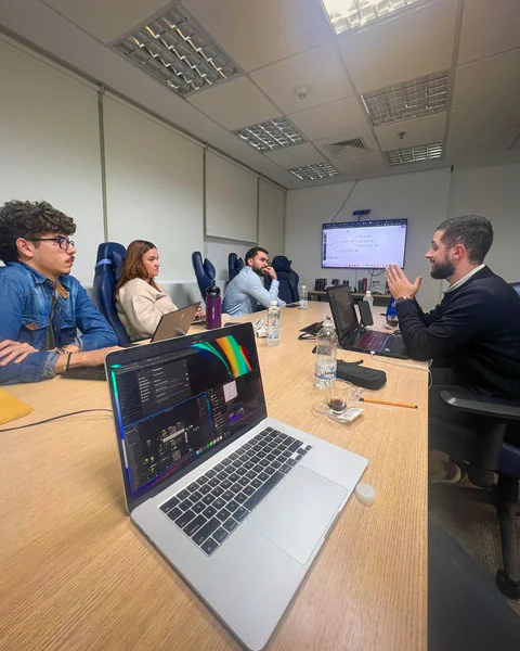 Matheus durante uma consultoria, conversando com participantes ao redor de uma mesa